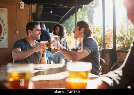 Zwei männliche Freunde treffen in Sports Bar, Toast zusammen Stockfoto