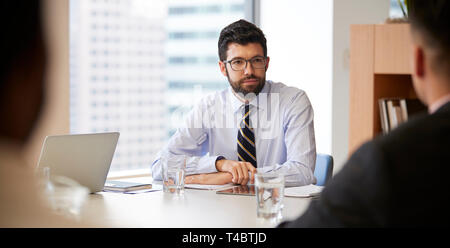 Geschäftsmann mit digitalen Tablet Sitzen am Tisch Treffen mit Kollegen in modernen Büro Stockfoto