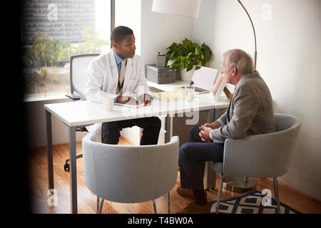 Ältere Menschen in Absprache mit männlicher Arzt im Krankenhaus Büro Stockfoto