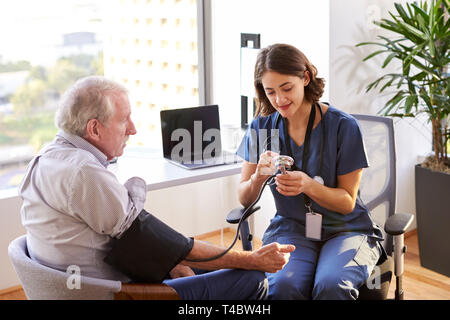 Krankenschwester tragen Peelings im Amt prüfen ältere männliche Patienten Blutdruck Stockfoto