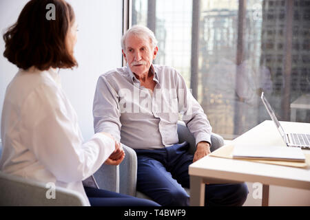 Ärztin im Amt Beruhigend älterer Mann Patient und seine Hände Stockfoto