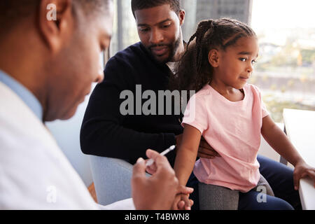 Vater der jungen Tochter für die Impfung im Doktorbüro Stockfoto
