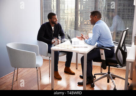 Lächelnd Mann treffen mit männlichen Finanzberater Beziehung Ratgeber in Office Stockfoto