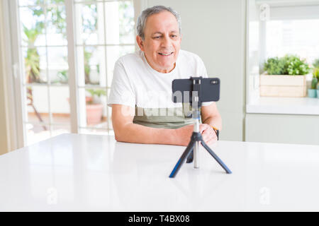 Gut aussehender älterer Mann lächelnd sehr zufrieden auf das Smartphone, Kamera, Video Stockfoto