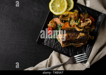 Gegrillte oder gebratene Seehecht Fisch auf schwarze Platte. Keta Diät und Ernährung Lebensmittel Konzept. Das gesunde Essen. Ansicht von oben. Kopieren Sie Platz. Stockfoto