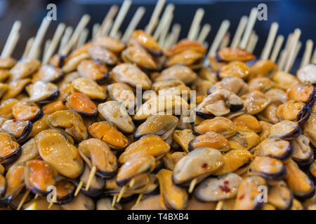 Köstliche Meeresfrüchte leckere Spieße mit Muscheln, aufgereiht auf Holzstäbchen Nahaufnahme. Stockfoto