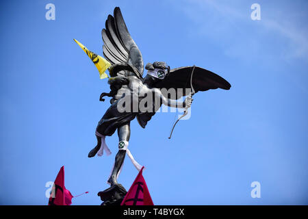 London, Großbritannien. 15. April 2019. Der Eros Statue in einer Augenbinde, die wie Menschen Piccadilly Circus während der 'besetzen London: Internationale Rebellion', ein Protest vom Aussterben Rebellion organisiert, fordert, dass Regierungen Maßnahmen gegen den Klimawandel ergreifen. Marble Arch, Oxford Circus, Piccadilly Circus, Waterloo Bridge und Parlament Platz haben von Aktivisten blockiert. Nach Angaben der Veranstalter, ähnliche Proteste gibt es in 80 weiteren Städten rund um die Welt. Credit: Stephen Chung/Alamy leben Nachrichten Stockfoto