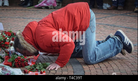 Sheffield, Großbritannien. 15 Apr, 2019. Ein Mann gesehen, Küssen ein Schal von Liverpool Fußball während der jährlichen Gedenkfeier am Hillsborough. Hunderte von Menschen außerhalb der Fußballplatz von Sheffield Mittwoch sammeln 30 Hillsborough Tragödie, die ihr Leben bei einem Andrang auf die Hillsborough Fußballplatz in Sheffield verloren zu gedenken. Credit: Ioannis Alexopoulos/SOPA Images/ZUMA Draht/Alamy leben Nachrichten Stockfoto