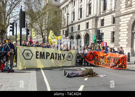 London, Großbritannien. 15 Apr, 2019. Die demonstranten gesehen halten zwei große Banner mit einem Mann bei einem toten Körper in der Mitte der Straße während das Aussterben Rebellion Demonstration in London. Aussterben Rebellion Demonstranten bringen London zum Stillstand. Die Demonstranten aufgereiht über die Ausfahrten zu den Parliament Square, Westminster, mit einigen Sitzen in der Straße. Die Gruppe Plan zu blockieren, die fünf der belebtesten und berühmtesten Orte in einer gewaltfreien, friedlichen Akt der Rebellion - für bis zu zwei Wochen Gutschrift: Keith Mayhew/SOPA Images/ZUMA Draht/Alamy leben Nachrichten Stockfoto