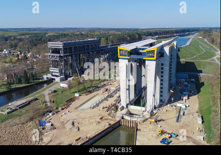 15. April 2019, Brandenburg, Niederfinow: Blick auf die Baustelle der Hubvorrichtung des neuen Schiff (r) und der alten Hoist, Luftaufnahme mit einer Drohne. Seit 2009, der Wasser- und Schifffahrtsverwaltung des Bundes wurde die Errichtung eines neuen Schiffes Aufzug in Niederfinow Die alten technischen Denkmal auf der Oder-Havel-wasserstraße von 1934, die als Engpass auf dem Wasserweg von Berlin an die Ostsee angesehen wird, zu ersetzen. Derzeit die unteren äußeren Hafen wird durch Bagger ausgegraben. Um dies zu tun, etwa 200.000 Kubikmeter Erde bewegt werden müssen. Führen Sie den Test Der neue Lift ist in zu beginnen. Stockfoto