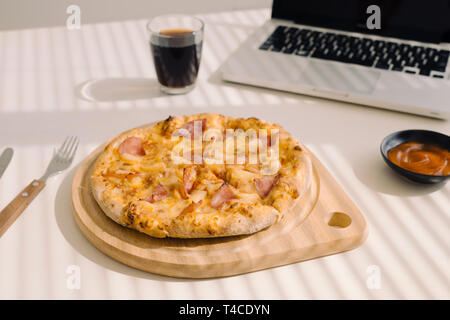 Leckere Pizza auf die Tabelle im Büro. Stockfoto