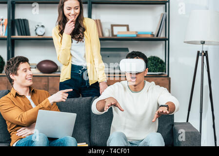 Drei lachen Freunde mit VR-Headset im Wohnzimmer Stockfoto