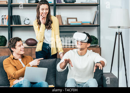 Drei lachen Freunde mit VR-Headset im Wohnzimmer Stockfoto