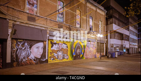 Bunte Straßen von Belfast bei Nacht mit Graffiti plattiert Bauruinen. Stockfoto