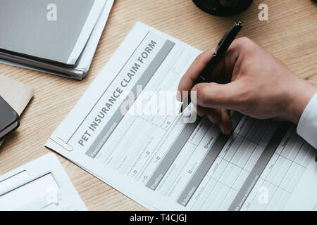 7/8-Ansicht von Mann, Abfüllung in Pet Insurance Claim Form Schutz Sicherheit Gesundheit Konzept Stockfoto