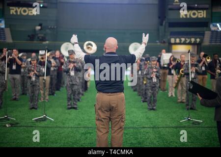 Us Air Force Maj. Michael Hoerber, Kommandant der USAF Band der Pacific-Asia gleichzeitig probt die Durchführung der Japan Air Verteidigung-kraft und USAF band Mitglieder für die Eröffnungsfeier der Major League Baseball Japan Reihe bei den Tokyo Dome, 20. März 2019. Das Stadion war ausverkauft Stockfoto