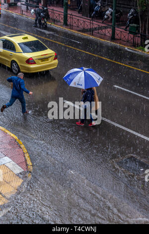 Starker Regen mit Hagel in der Innenstadt von Athen. Die filellinon Avenue ist fast Flut und die Menschen haben eine harte Zeit, über. Stockfoto