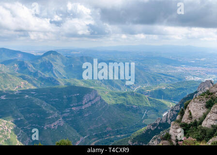 Hazy ungewöhnliche Berge mit grünen Bäumen und bewölkter Himmel in der Nähe von Kloster Montserrat, Spanien. Katalonien Stockfoto