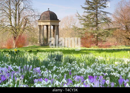 Der Tempel der Winde an doddington Halle und Gärten, Lincolnshire aus einem Rasen eingebürgerten Krokusse und Schneeglöckchen, - Ende Februar, UK gesehen Stockfoto