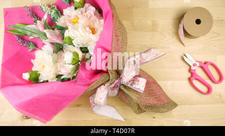 Blumen in rosa Gewebe und Hessischen moderne Verpackung flach verpackt für Muttertag, Geburtstag oder Valentinstag feiern. Stockfoto