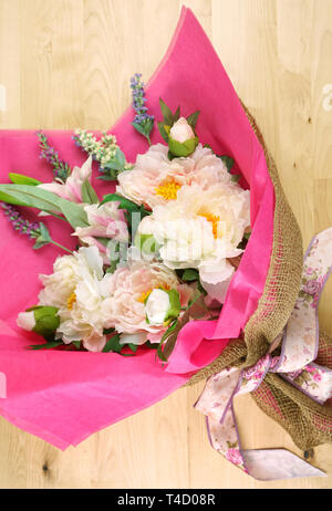 Blumen in rosa Gewebe und Hessischen moderne Verpackung flach verpackt für Muttertag, Geburtstag oder Valentinstag feiern. Stockfoto