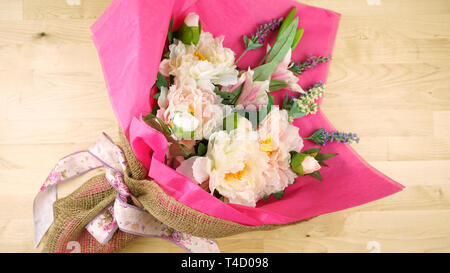 Blumen in rosa Gewebe und Hessischen moderne Verpackung flach verpackt für Muttertag, Geburtstag oder Valentinstag feiern. Stockfoto
