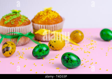 Muffins mit Spachtelmasse besprüht, Blumen, Grün und Gelb Ostern Wachteleier auf Pastell rosa Hintergrund. Kopieren Sie Platz. Close Up. Ostern Holida Stockfoto