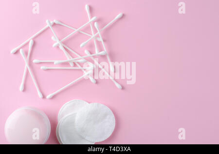 Ohr Sticks und Wattepads auf Pastell rosa Hintergrund. Entfernen von Make-up und Hautpflege. Platz für Text Stockfoto