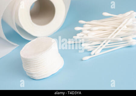 Ohr Sticks, Wattepads und Klopapierrolle auf Pastell-blaue Hintergrund. Body Care Konzept. Platz kopieren Stockfoto