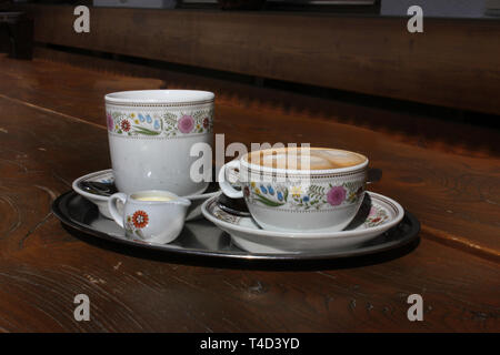 Kellner mit zwei Kaffeesorten, Americano und Cappuchino. Hinweis auf Kaffee und Espresso. Stockfoto