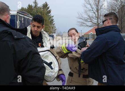 Ew York Army National Guard Staff Sgt. Sean Durst und Sgt. Madalena Noyes, beide Mitglieder der 24 zivilen Support Team, sind in ihrer Ausrüstung geholfen, wie sie sich vorbereiten, ein verdächtiges Fahrzeug während einer nuklearen, biologischen, chemischen, radiologischen Antwort Bohren am Hamilton College in Clinton, New York, am 21. März 2019 prüfen. Mitglieder der 2. und 24. Zivile der New Yorker Nationalgarde Support Team, 21 zivile Support Team der New Jersey der National Guard, der durchgeführten Übungen vom 18. März bis 21 am Hamilton College zusammen mit Mitgliedern des New York State Police, Hamilton College die öffentliche Sicherheit, die N Stockfoto