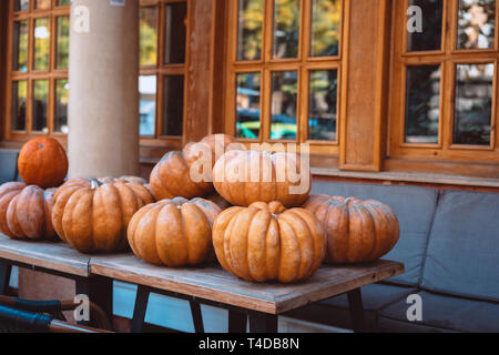 Viele große orange Kürbisse liegen auf der Straße. Herbst Straße Dekoration. Stockfoto