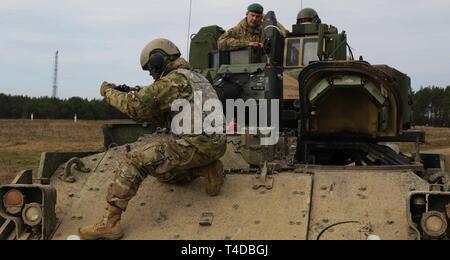 Brig. Gen. Leigh Tingey, stellvertretender kommandierender General der 1. gepanzerten Abteilung von Fort Bliss in Texas, sitzt in einem M2A3 Bradley Fighting Fahrzeug als Pfc. Natnael Getahun, ein infanterist mit der 1 Battalion, 35th Armored Regiment, 2nd Brigade Combat Team, 1. Panzerdivision, behebt das Wildschwein aus den Augen, um die Genauigkeit zu gewährleisten, wenn sie feuert, während einer Live-fire Übung in Drawsko Pomorskie, Polen, 24. März. An der Richtung des Verteidigungsministers der 2. Gepanzerten Brigade Combat Team, 1. Panzerdivision, bereitgestellt von Europas Fähigkeit der US-Armee zur Übung Stockfoto