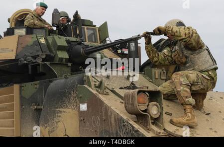 Brig. Gen. Leigh Tingey, stellvertretender kommandierender General der 1. gepanzerten Abteilung von Fort Bliss in Texas, sitzt in einem M2A3 Bradley Fighting Fahrzeug als Pfc. Natnael Getahun, ein infanterist mit der 1 Battalion, 35th Armored Regiment, 2nd Brigade Combat Team, 1. Panzerdivision, behebt das Wildschwein aus den Augen, um die Genauigkeit zu gewährleisten, wenn sie feuert, während einer Live-fire Übung in Drawsko Pomorskie, Polen, 24. März. An der Richtung des Verteidigungsministers der 2. Gepanzerten Brigade Combat Team, 1. Panzerdivision, bereitgestellt von Europas Fähigkeit der US-Armee zur Übung Stockfoto