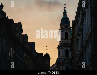 St. Nikolaus Kirche in Prag bei Sonnenuntergang im Frühjahr 2019 - mit den feinen Details der Uhr und Dekoration Stockfoto