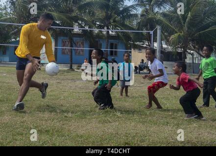 ENNIBURR, Republik der Marshall Inseln (25. März 2019) US-Marine Information Systems Techniker 3. Klasse Steven Maciel spielt Ball mit Marshallese Kinder während einer Gesundheit und Sport Messe während der Pacific Partnerschaft 2019. Pazifische Partnerschaft, der nun in seinem 14. Iteration, ist die größte jährliche internationale humanitäre Hilfe und Katastrophenhilfe Abwehrbereitschaft Mission im Indopazifik durchgeführt. Jedes Jahr, die Mission Team arbeitet gemeinsam mit Gastgeber und Partner Nationen regionaler Interoperabilität und Disaster Response Funktionen, erhöht die Stabilität und Sicherheit in der Reg zu verbessern Stockfoto