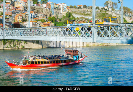 PORTO, PORTUGAL - NOVEМBER 13, 2016: Touristenboot vorbei unter Dom Luis Brücke mit gelben tour bus, Porto, Portugal Stockfoto