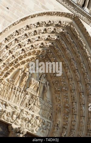 Sunlit Steinmetzarbeiten - Abbildungen oben Tür betreten der Kathedrale Notre Dame, Paris (Frankreich). Engel und Menschen und Christus. Christlich-religiöse Figuren Stockfoto