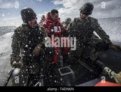 Ozean (April 2, 2019) - Matrosen an Bord der Arleigh-Burke-Klasse geführte Anti-raketen-Zerstörer USS Carney (DDG64), Fahrt in eine Starre - Rumpf Schlauchboot als Teil des Besuchs, Board, Suche, und Beschlagnahme Team während der multinationale Übung gemeinsame Krieger 19-1, 2. April 2019. Carney, Vorwärts - Rota, Spanien bereitgestellt ist auf der sechsten Patrouille in den USA 6 Flotte Bereich der Maßnahmen zur Unterstützung der regionalen Verbündeten und Partnern sowie die nationale Sicherheit der USA Interessen in Europa und Afrika. Stockfoto