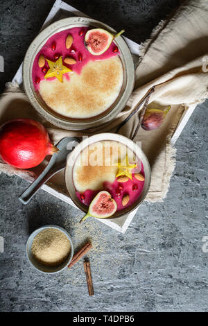 Grießbrei mit hausgemachten Granatapfel Sirup, mit Stern Obst, Feigen und Mandeln eingerichtet Stockfoto