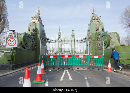 Ein Junge auf einem Roller überquert die Hammersmith Bridge, die nun für Autos und Busse auf unbestimmte Zeit gesperrt ist, aber weiterhin für Fußgänger und Radfahrer geöffnet ist Stockfoto