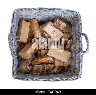 Isolierte alte Korb von Cut Brennholz in einem rustikalen Weidenkorb Stockfoto