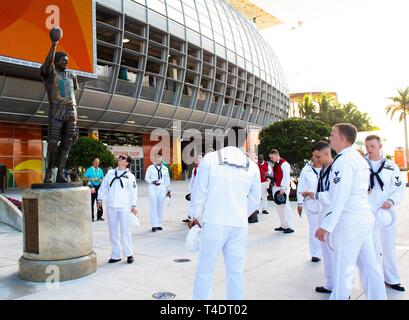 MIAMI (25. März 2019) Segler auf USS Florida (SSGN 728) und USS Verfassung zugewiesenen Surround eine Skulptur des ehemaligen Miami Dolphins Quarterback Dan Marino im Hard Rock Stadion während Miami Marine Woche, am 25. März. Miami Marine Woche, März 25-31, ist eine Reihe von Veranstaltungen im Miami Bereich, Aufklärung über die Marine zu fördern und die Beziehungen mit der Gemeinschaft. Es ist eine der 14 Marine Wochen von der Marine Büro für Öffentlichkeitsarbeit im Jahr 2019 organisiert, und zum ersten Mal in Miami eine Marine Woche bewirtet hat. Stockfoto