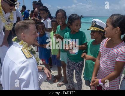 ENNIBURR, Republik der Marshall Inseln (26. März 2019) US Navy hinten Adm. Joey Tynch lässt einen Marshallese Kind versuchen, auf seine Deckung am Eniburr pier Während der Pacific Partnerschaft 2019. Pazifische Partnerschaft, der nun in seinem 14. Iteration, ist die größte jährliche internationale humanitäre Hilfe und Katastrophenhilfe Abwehrbereitschaft Mission im Indopazifik durchgeführt. Jedes Jahr, die Mission Team arbeitet gemeinsam mit Gastgeber und Partner Nationen regionaler Interoperabilität und Disaster Response Funktionen, erhöhen die Stabilität und Sicherheit in der Region zu stärken, und neue und dauerhafte friendsh Stockfoto