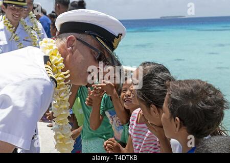 ENNIBURR, Republik der Marshall Inseln (26. März 2019) Royal Navy Capt. Paddy Allen, Direktor von Mission, spricht mit Marshallese Kinder auf dem Enniburr Pier nach der Ankunft für einen Spatenstich während der Pacific Partnerschaft 2019. Pazifische Partnerschaft, der nun in seinem 14. Iteration, ist die größte jährliche internationale humanitäre Hilfe und Katastrophenhilfe Abwehrbereitschaft Mission im Indopazifik durchgeführt. Jedes Jahr, die Mission Team arbeitet gemeinsam mit Gastgeber und Partner Nationen regionaler Interoperabilität und Disaster Response Funktionen, erhöht die Stabilität und Sicherheit zu verbessern Stockfoto