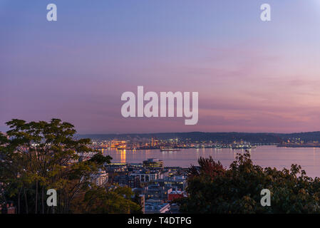 Der Himmel nimmt auf einem violetten Ton in der Dämmerung im Hafen von Seattle und Elliott Bay. Stockfoto