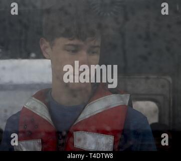 Ein Navy Junior Reserve Officer Training Corps Cadet sieht durch das Fenster auf eine mechanisierte Landing Craft in der Nähe der Marine Corps Air Station Cherry Point, North Carolina, 20. März 2019. Die kadetten waren zu Besuch aus Anderson County High School in Clinton, Tennessee. Der Besuch gab den Kadetten eine Chance einen Einblick in zahlreiche militärische Operationen auf einem Marine Corps Installation zu sehen. Stockfoto