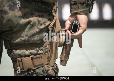 Sgt. Alejandro Pena, eine Bildsprache Analytiker mit der 31 Marine Expeditionary Unit, bereitet eine M9A1 9-mm-Pistole auf ein Ziel zu Brand während der Präqualifikation im Bereich 106, Camp Hansen, Okinawa, Japan, 26. März 2019. Pena, ein Eingeborener von Corona, Kalifornien, graduiert von Centennial High School im Juni 2006, bevor er von RS Santa Ana im November 2009. Die 31. MEU, das Marine Corps' nur kontinuierlich vorwärts - bereitgestellt MEU, bietet eine flexible und tödlicher Gewalt bereit, ein breites Spektrum an militärischen Operationen in der gesamten indopazifischen Region durchzuführen. Stockfoto