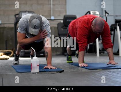 Flieger durchführen, cross-arm Pushups während einer bestimmten Klasse von Tech. Sgt. Dacia Lucas, 104 Instandhaltungsgruppe Aircraft Engine Mechaniker, 26. März 2019, bei Barnes Air National Guard Base, Massachusetts. Die Klassen werden von 11:15 bis 11:45 Uhr Dienstags und Donnerstags als ein Weg, um zu gewährleisten, dass die Flieger fit sind zu kämpfen. Stockfoto