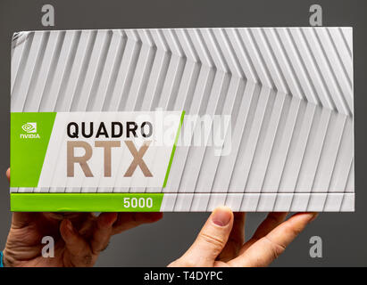 Paris, Frankreich - 28.März 2019: älterer Mann zeigen Kartons vor dem Auspacken des Nvidia Quadro RTX 5000 Workstation GPU mit neuen Tensor Kerne - grauer Hintergrund Stockfoto